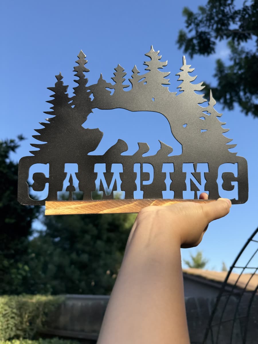 Bear and pine trees above the word Camping, cut from steel.