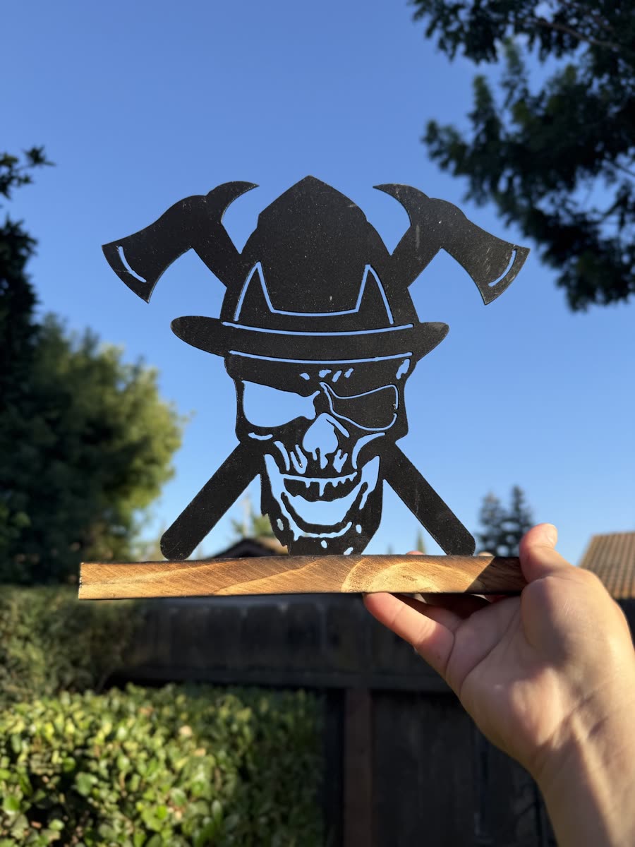 Skull in a firefighter helmet with crossed axes behind it.