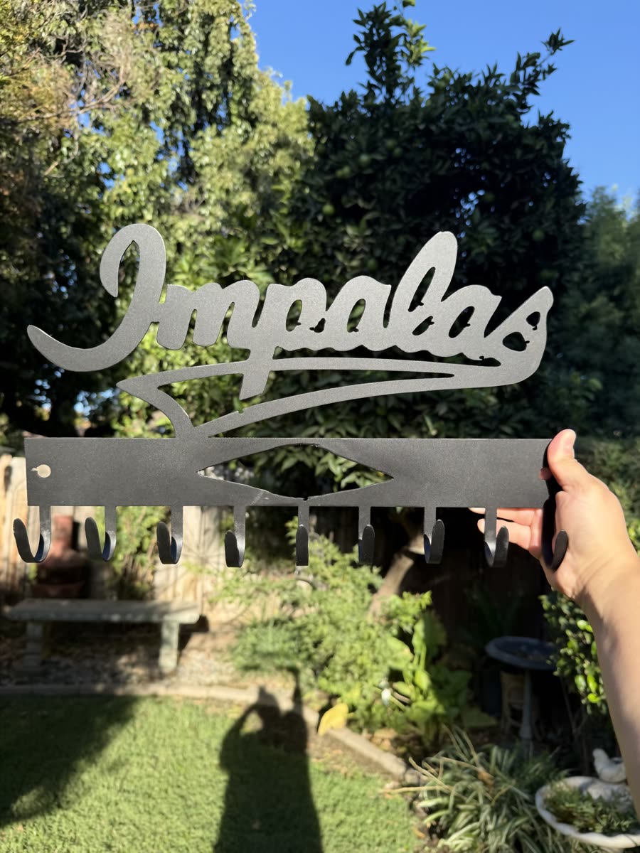 The word Impalas cut in flowing script from steel.