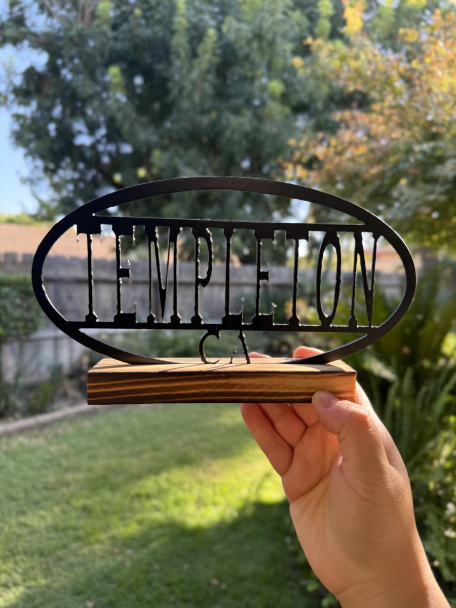Templeton CA cut inside a steel oval on a wooden base.