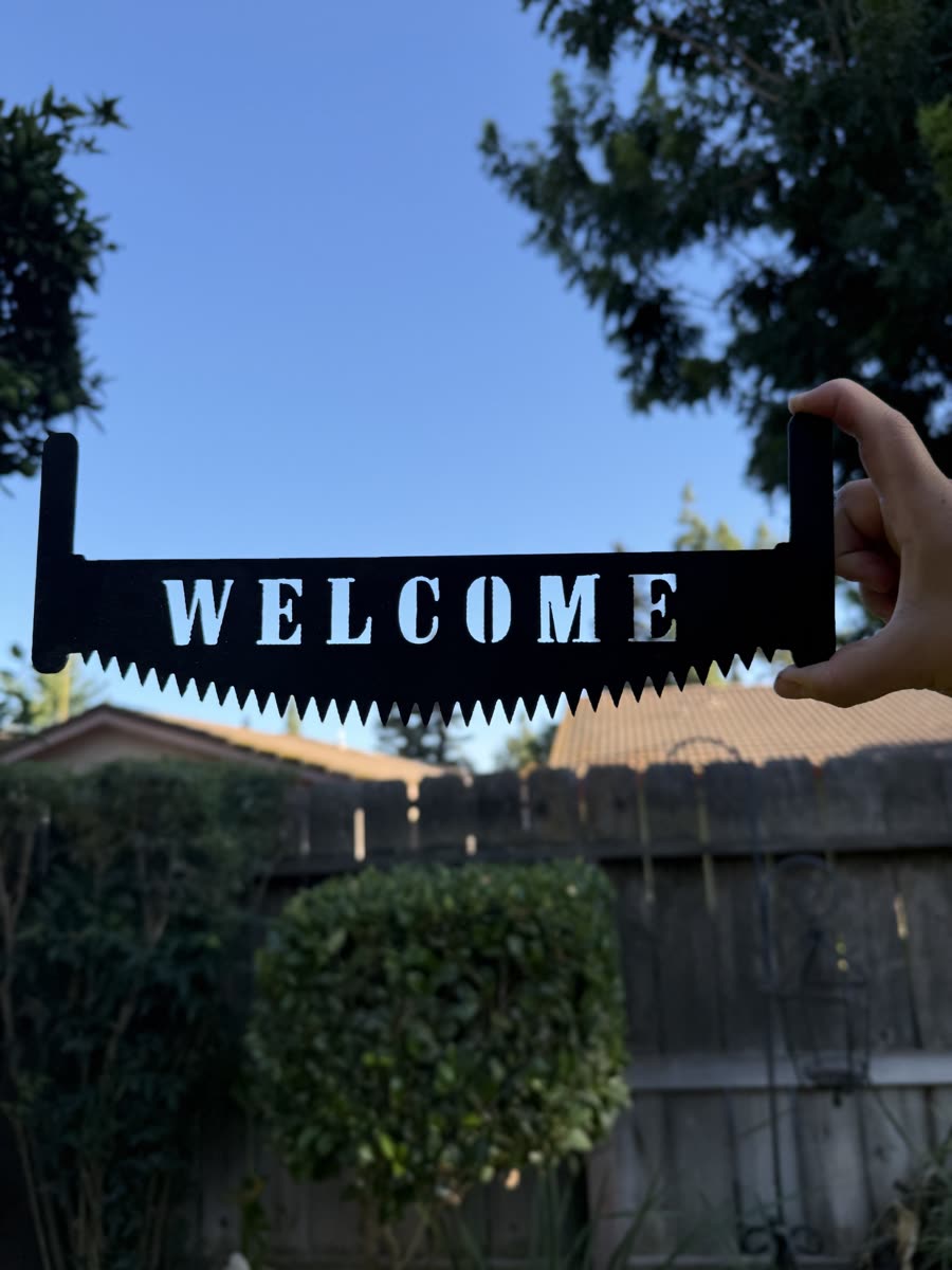 The word Welcome cut through the blade of a handsaw.